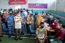 Kadiskes Riau Mimi Yuliani Nazir mendampingi Gubernur Riau (Gubri) Syamsuar dalam kegiatan baksos vaksinasi massal dalam rangka peringatan HUT TNI ke 76 tahn 2021 di Lapangan GOR Andalan Lanud Roesmin Nurjadin